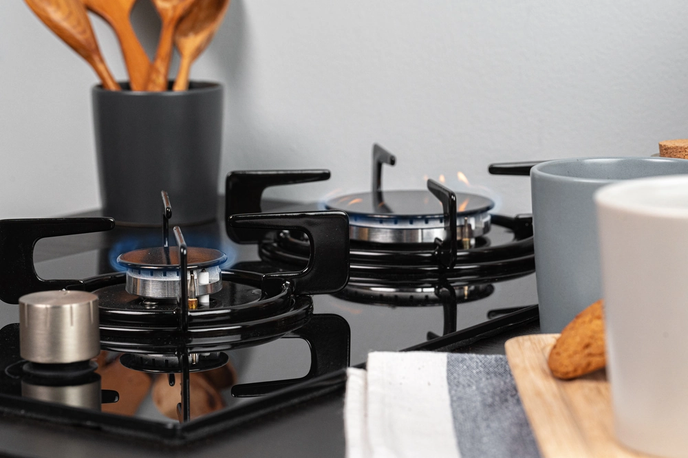 Blatowa kuchenka gazowa z palnikami, naczynie z przyborami kuchennymi i elementy wyposażenia